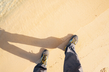 Hiking shoes walking on a sandy beach
