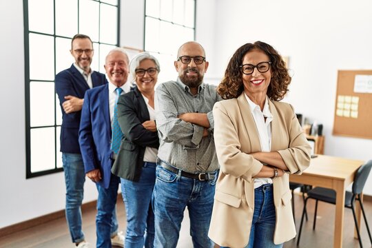 Group of middle age business workers smiling happy standing with arms crossed gesture at the office