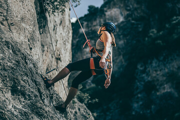 Woman descending a cliff after a hard climb route - 487086023