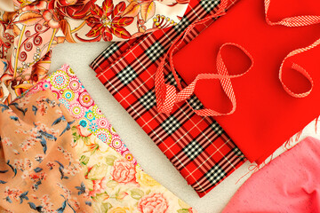 Various fabrics on the table are ready for sewing. Lots of colorful fabric in red shades. Textiles...