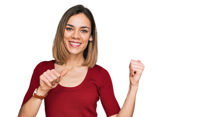 Fototapeta premium Young blonde girl wearing casual clothes pointing to the back behind with hand and thumbs up, smiling confident