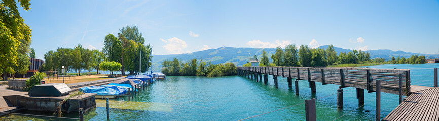 lakeside Zurichsee with moored boats, wooden bridge, tourist destination Rapperswil-Jona