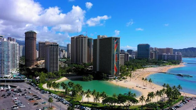 Circling right aerial shot of the Hilton resort in Waikiki Hawaii with a beautiful lagoon on the Pacific Ocean next to the Marina.