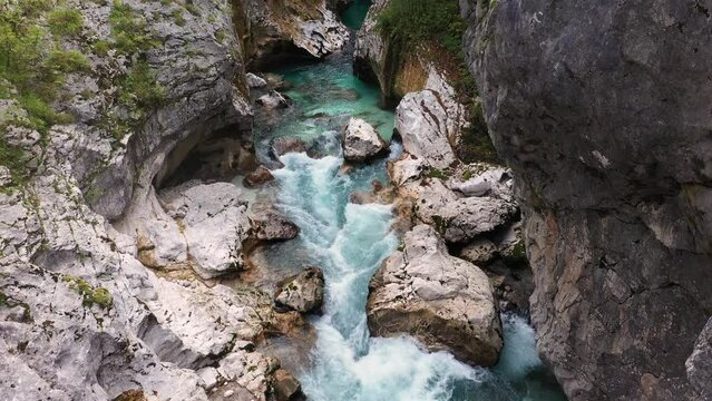 Aerial View Above The Surface Of A Mountain River Soca , stream flowing through rocky canyon. River stones with flowing water, clean water flowing in a mountain river