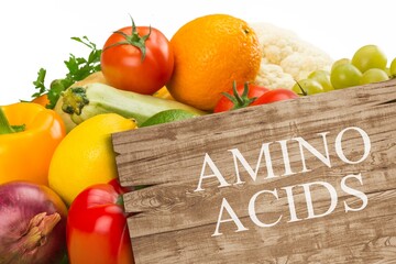 Wooden board with text AMINO ACIDS among different products and vegetables