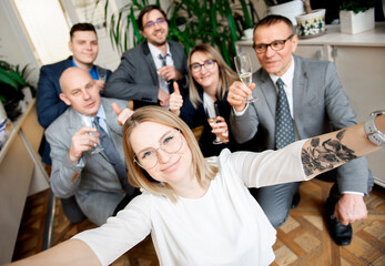 Fototapeta na wymiar Happy business people team with champagne glasses taking selfie at business meeting