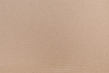 The texture of the surface of brown packaging cardboard for boxes in close-up.