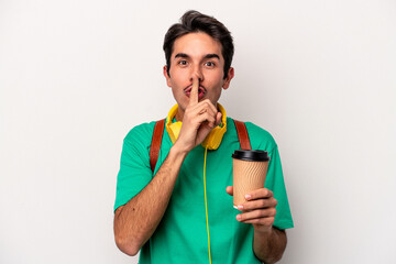 Young caucasian student man drinking coffee isolated on white background keeping a secret or asking...