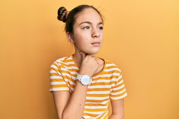 Beautiful brunette little girl wearing casual striped t shirt touching painful neck, sore throat for flu, clod and infection