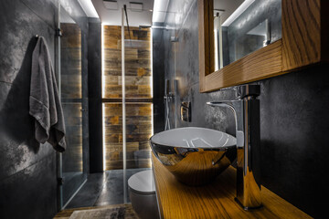 Stylish dark bathroom interior with shower. Tiles imitating wood on the floor and on the wall - obrazy, fototapety, plakaty