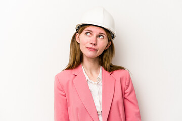 Young architect English woman with helmet isolated on white background dreaming of achieving goals and purposes