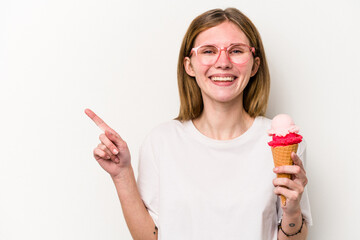 Young English woman holding an ice cream isolated on white background smiling and pointing aside, showing something at blank space.