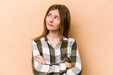 Young English woman isolated on beige background dreaming of achieving goals and purposes