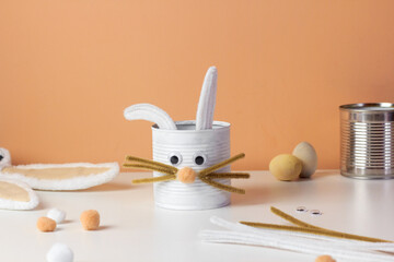 Reuse concept art from tin can. Eco friendly bunny craft. Handmade decoration easter rabbit. Kids DIY ideas