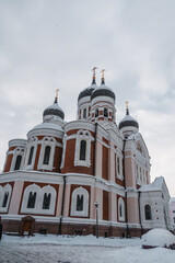 Fototapeta na wymiar High white-and-red church with domes. Church in the winter city (1163)