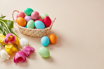 Fototapeta na wymiar Colorful Easter eggs basket and tulips