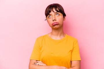Young hispanic woman isolated on pink background tired of a repetitive task.