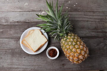Fototapeta na wymiar Slice bread with pineapple fruit and jam on wood background