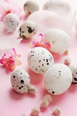 easter quail eggs and flowers on pastel pink background