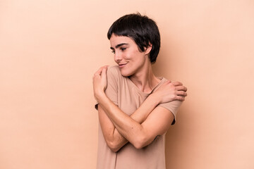 Young caucasian woman isolated on beige background hugs, smiling carefree and happy.