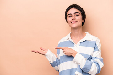 Young caucasian woman isolated on beige background excited holding a copy space on palm.