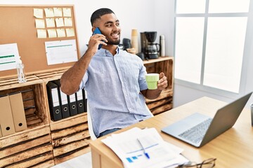Young arab man talking on the smartphone working at office