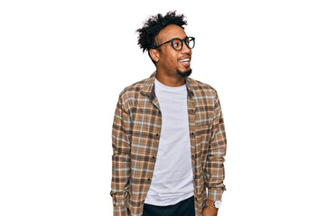 Young african american man with beard wearing casual clothes and glasses looking away to side with...