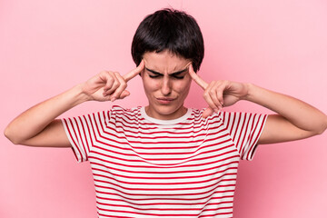Young caucasian woman isolated on pink background focused on a task, keeping forefingers pointing head.