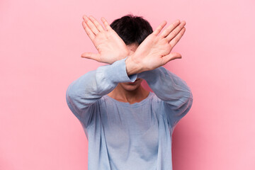 Young caucasian woman isolated on pink background keeping two arms crossed, denial concept.