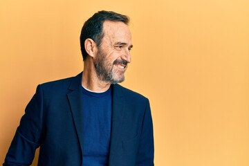 Middle age hispanic man wearing business clothes looking to side, relax profile pose with natural...