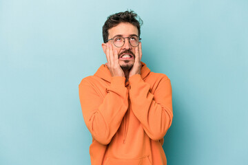 Young caucasian man isolated on blue background whining and crying disconsolately.
