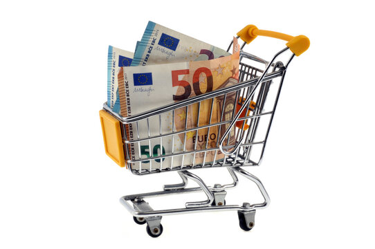 Billets de banque de cinquante et vingt euros dans un chariot de supermarché sur fond blanc