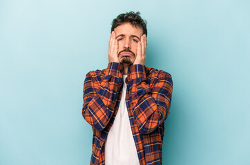 Fototapeta premium Young caucasian man isolated on blue background whining and crying disconsolately.