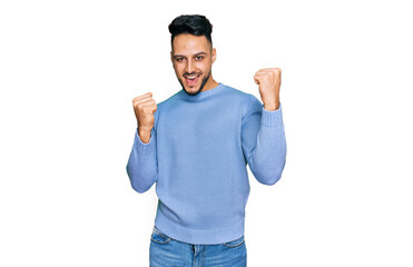Fototapeta premium Young arab man wearing casual clothes screaming proud, celebrating victory and success very excited with raised arms