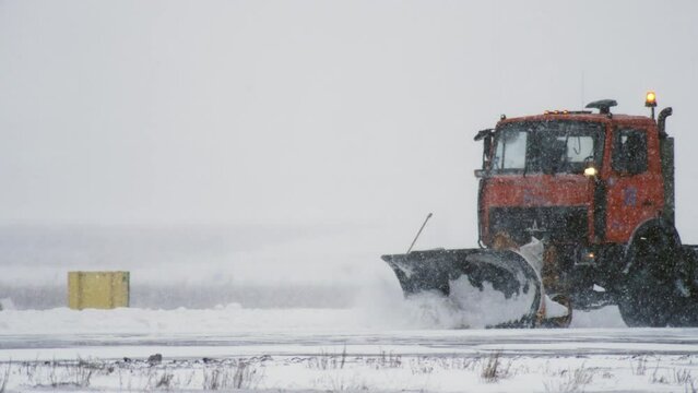 Snowplows working at the airport clearing the runway in the snow in winter slow motion