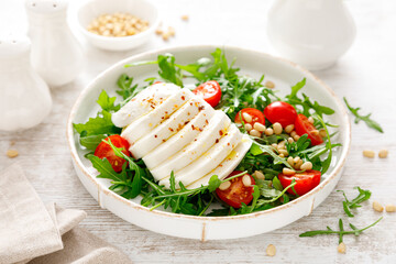 Salad with arugula, mozzarella cheese and pine nuts. Breakfast. Ketogenic, keto or paleo diet....