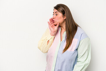 Young caucasian overweight woman isolated on white background is saying a secret hot braking news and looking aside