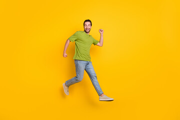Fototapeta na wymiar Full size profile side photo of young guy good mood active motion runner rush jump isolated over yellow color background