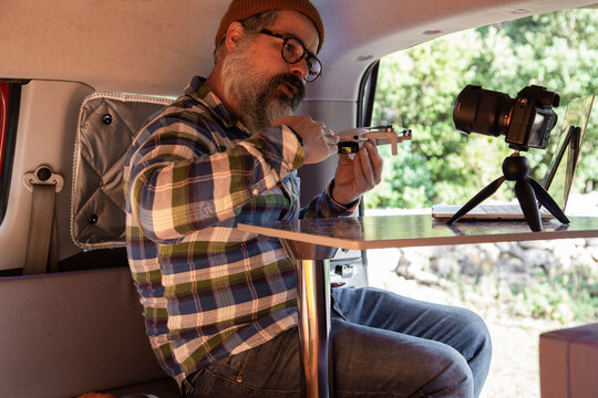 Elderly man with drone recording video in camper