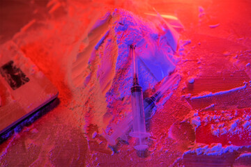 Drugs, drug dealer's house. Cocaine packaged in sachets, scales: tablets and syringes in neon...