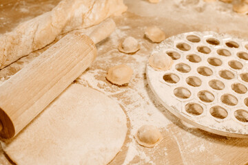 Making homemade dumpling dough. The rolling pin rolls out dough, flour and a mold for dumplings or...