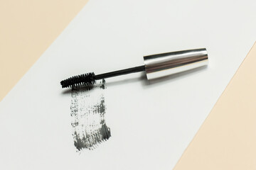 Mascara lies on a white background, and leaves a black mark showing how the brush works. Cosmetics and make-up personal care