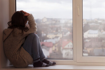Stressed Sad Teen sitting alone and looking out the window. Depressed Upset Teenager has problems....