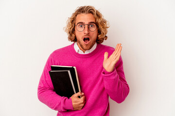 Young student caucasian man isolated on white background surprised and shocked.