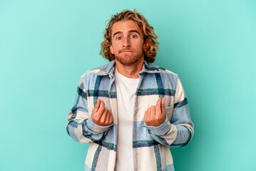Young caucasian man isolated on blue background showing that she has no money.