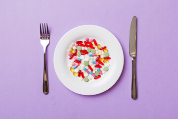 Many different weight loss pills and supplements as food on round plate. Pills served as a healthy meal. Drugs, pharmacy, medicine or medical healthycare concept