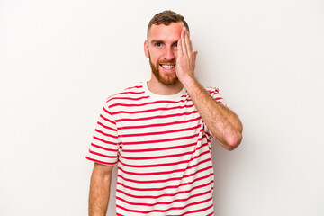 Young caucasian man isolated on white background having fun covering half of face with palm.