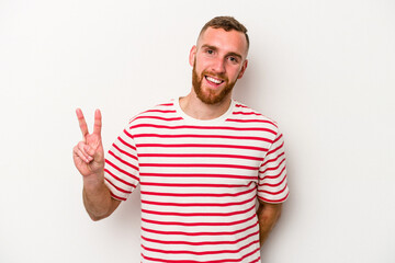 Naklejka premium Young caucasian man isolated on white background showing victory sign and smiling broadly.