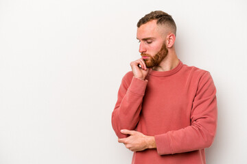 Young caucasian man isolated on white background looking sideways with doubtful and skeptical expression.