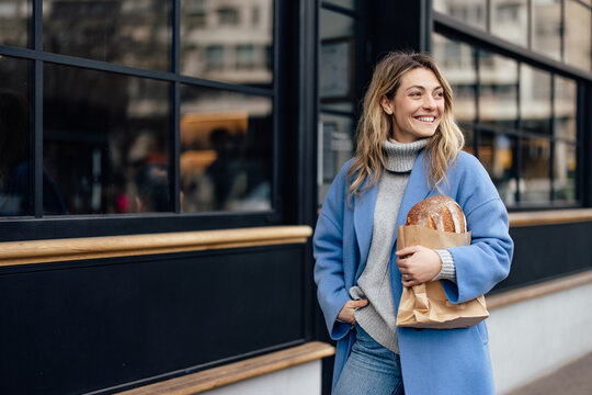 Lovely caucasian woman in blue jacket, smiling to her friend across the street.